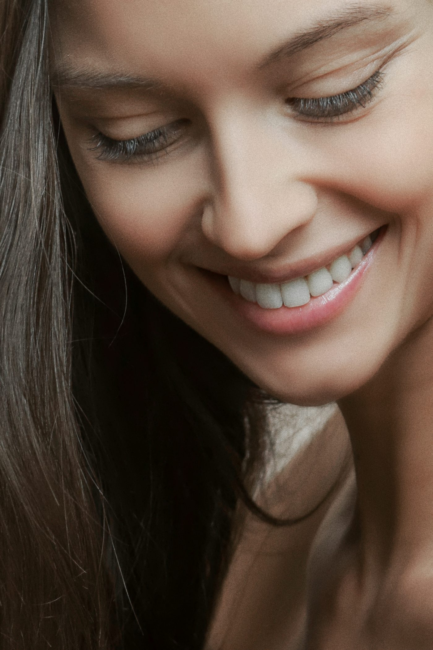 Close-up of a woman with a natural, confident smile after veneers